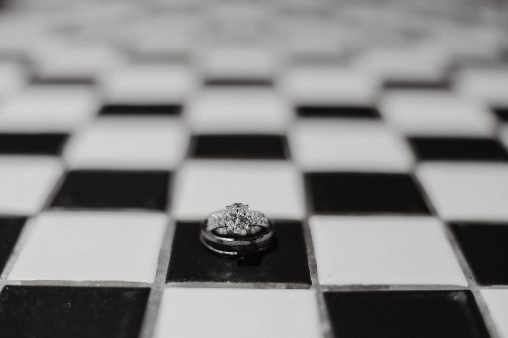 Close up detail shot of bride and groom's ring on a checkered countertop