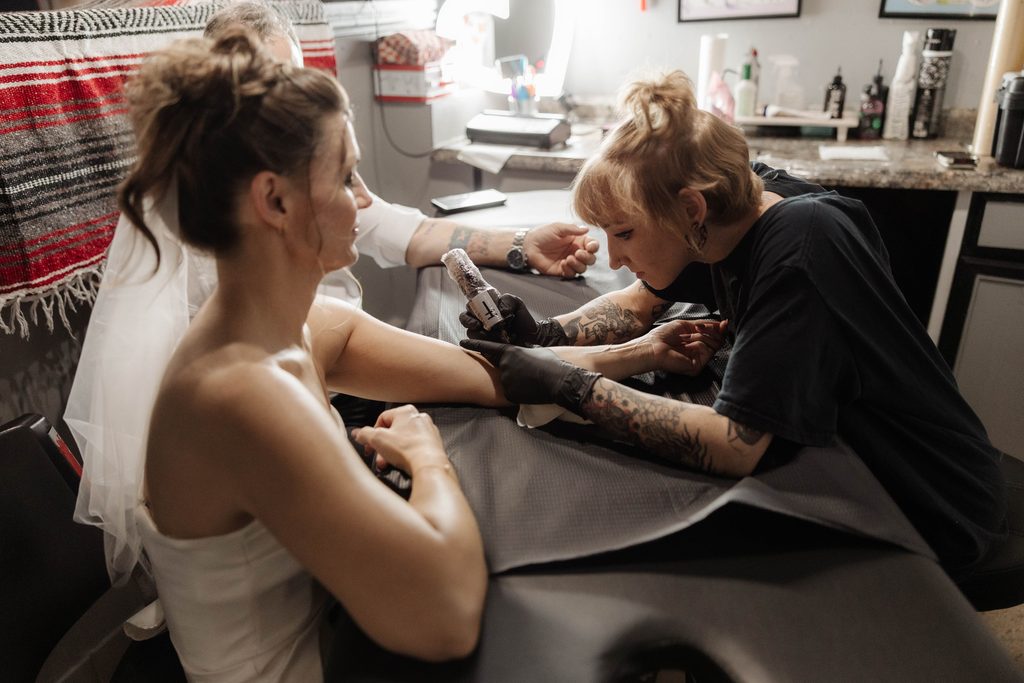 Bride and groom getting tattoos together at Knuckle Up Tattoo shop at the Fort Worth Stockyards
