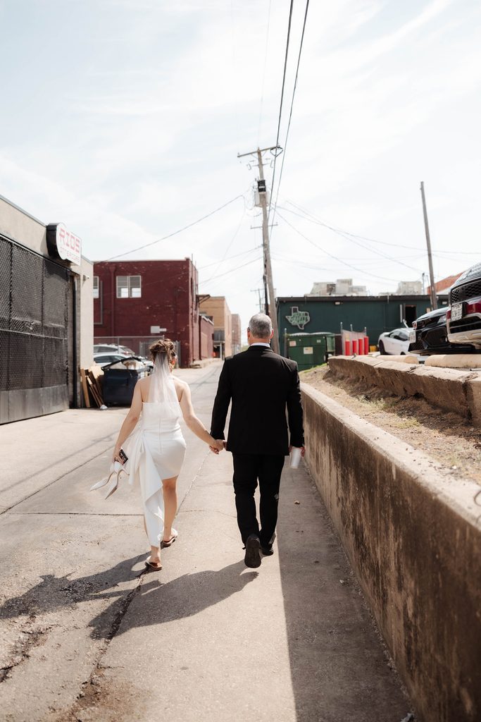 Bride and groom walking down an alley in the Fort Worth Stockyards