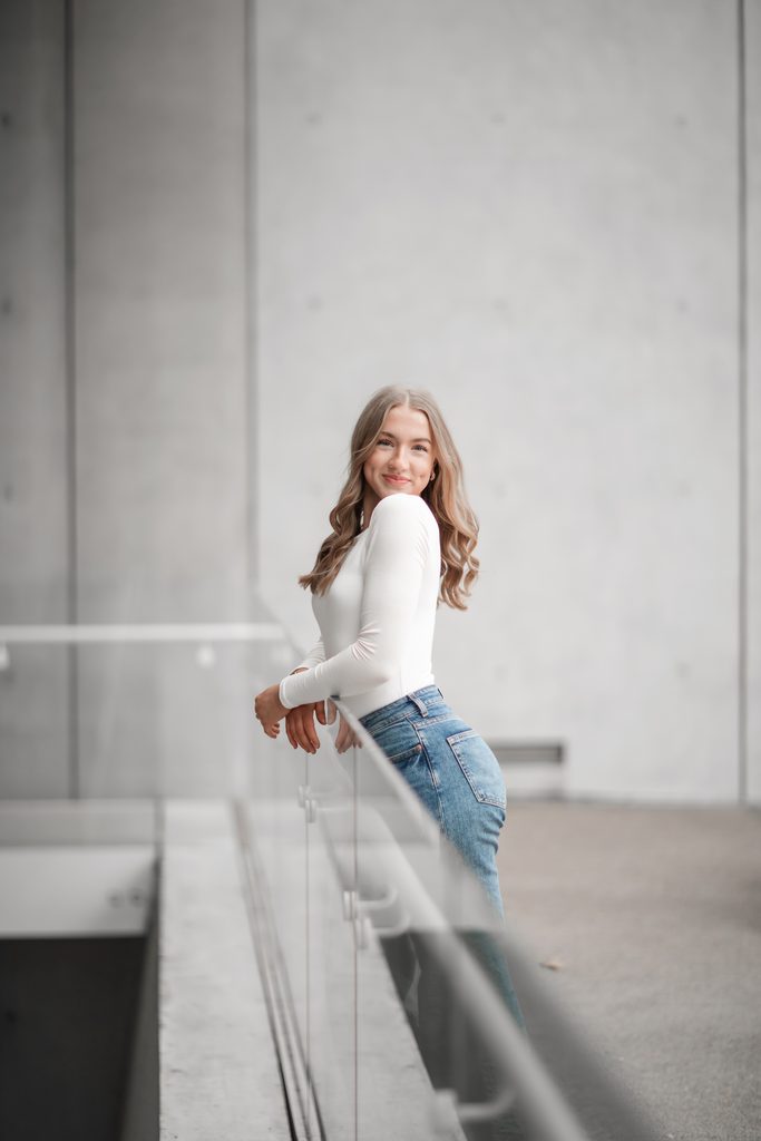 Girl posing along the railing at the Kimbell Art Museum during her senior portrait session