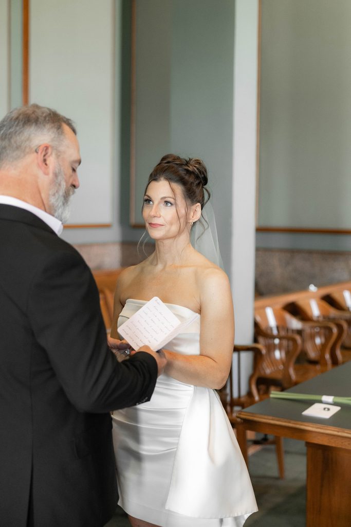 Bride + Groom exchanging vows at the Tarrant County Courthouse during their adventure elopement in Fort Worth