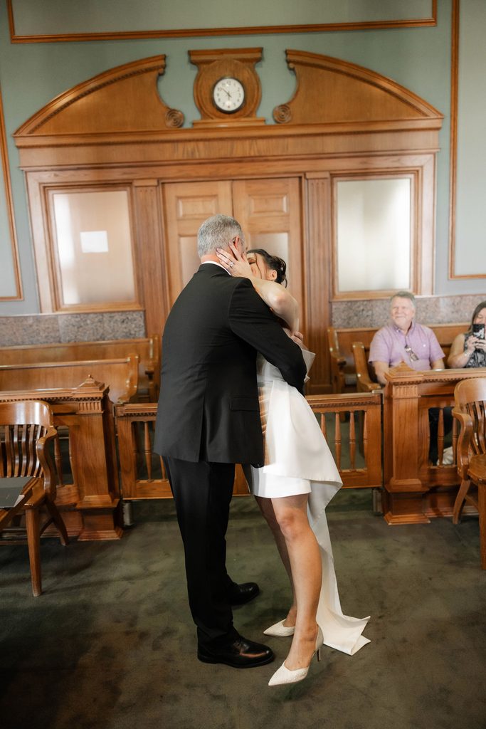Bride + Groom kissing in the courtroom in the Tarrant County Courthouse during their adventure elopement in Fort Worth