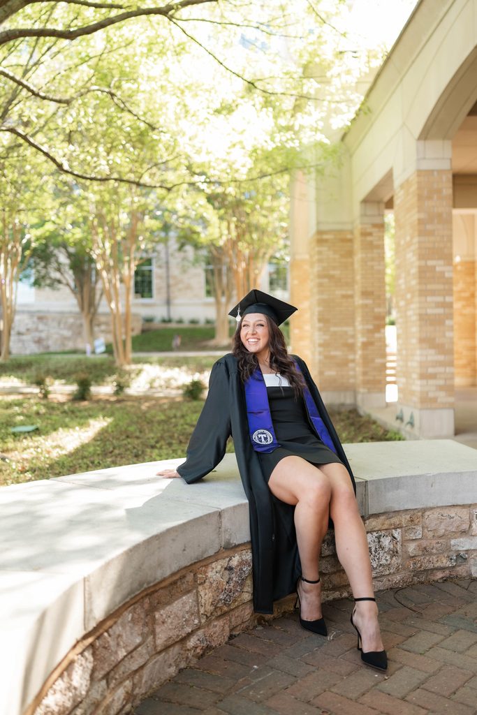Dramatic lighting portrait of girl posing during her grad session at the TCU Campus in Fort Worth, TX